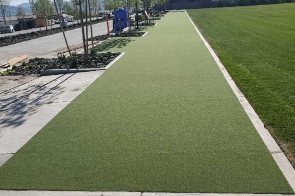 Edmonton Outdoor tee line consisting of one continuous green synthetic grass strip surrounded by trees